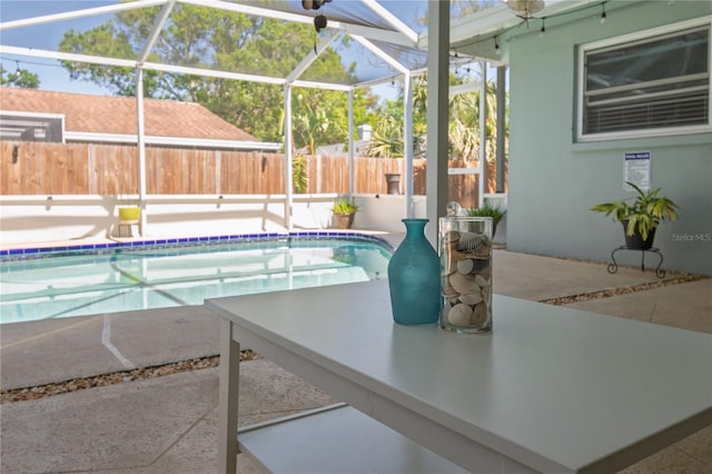 view of swimming pool featuring a fenced in pool, glass enclosure, a patio, and fence