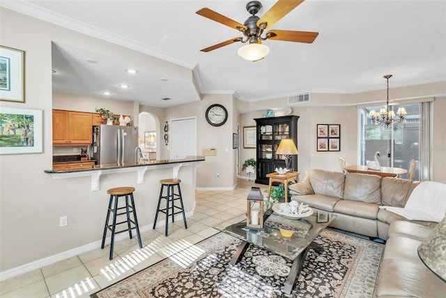 living room featuring ornamental molding, arched walkways, visible vents, and light tile patterned floors