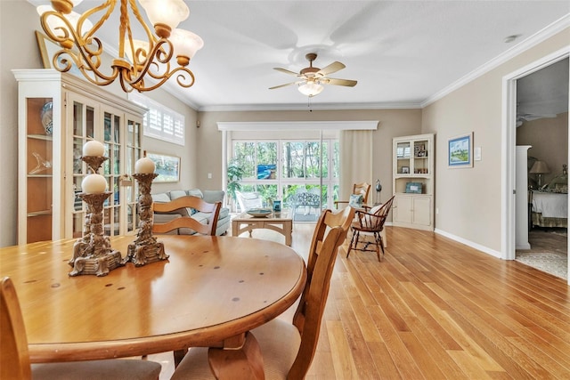 dining room with light wood-style floors, baseboards, ornamental molding, and ceiling fan with notable chandelier