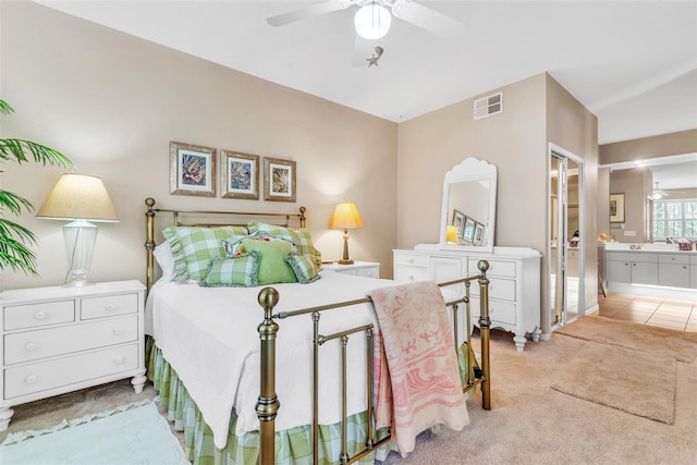 bedroom with a ceiling fan, visible vents, ensuite bath, and carpet flooring