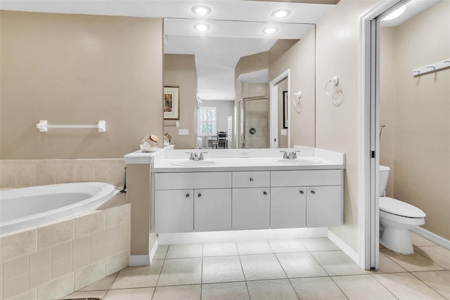 full bath with double vanity, toilet, a sink, a shower stall, and tile patterned flooring