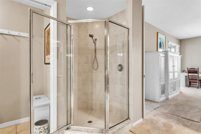 full bath with a stall shower, baseboards, and tile patterned floors