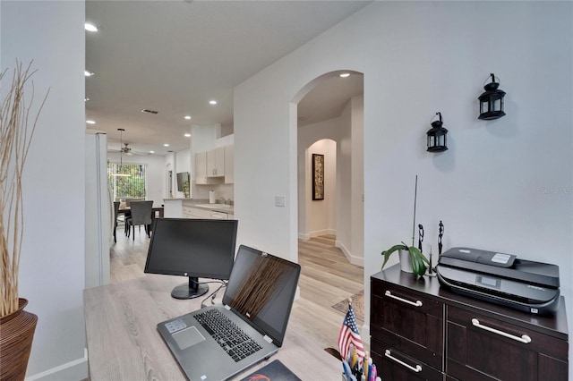 office area featuring baseboards, recessed lighting, light wood-style flooring, arched walkways, and a ceiling fan