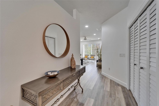 corridor featuring recessed lighting, visible vents, baseboards, and wood finished floors