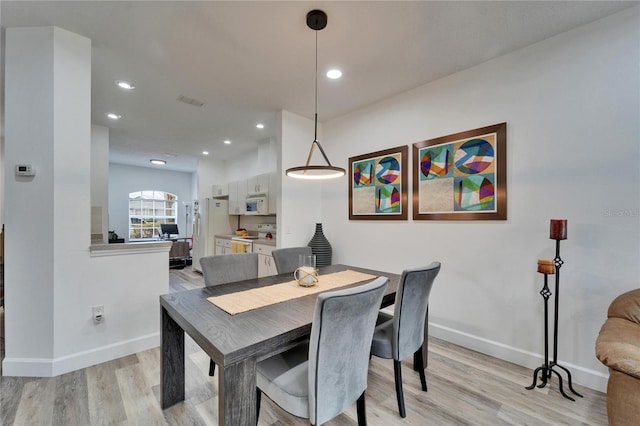 dining space featuring light wood-style flooring, recessed lighting, and baseboards