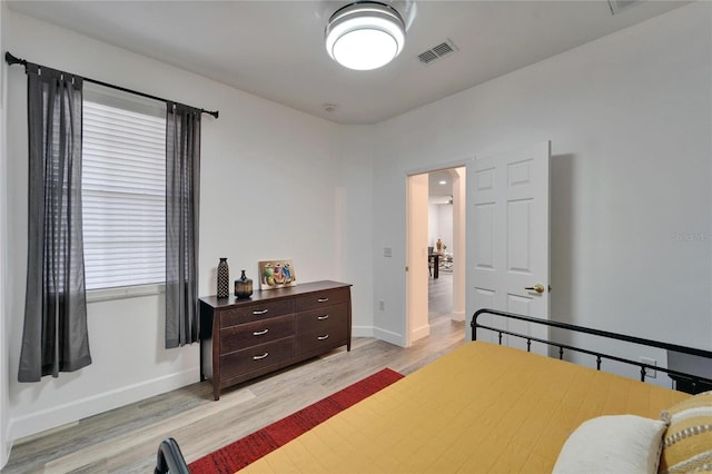 bedroom with visible vents, baseboards, and light wood-style flooring