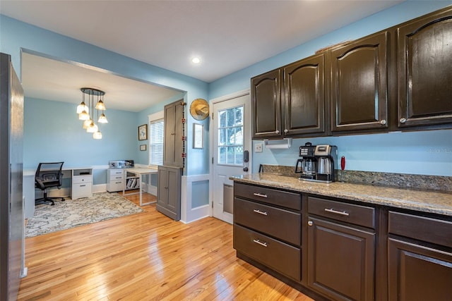 kitchen featuring light wood-style flooring and dark brown cabinets