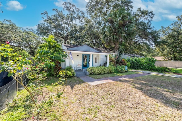 view of front facade featuring fence, a porch, and a front yard