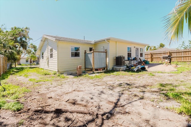 rear view of house featuring a patio area, cooling unit, and fence