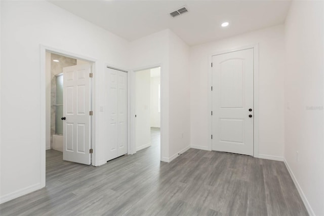 spare room with recessed lighting, visible vents, baseboards, and wood finished floors