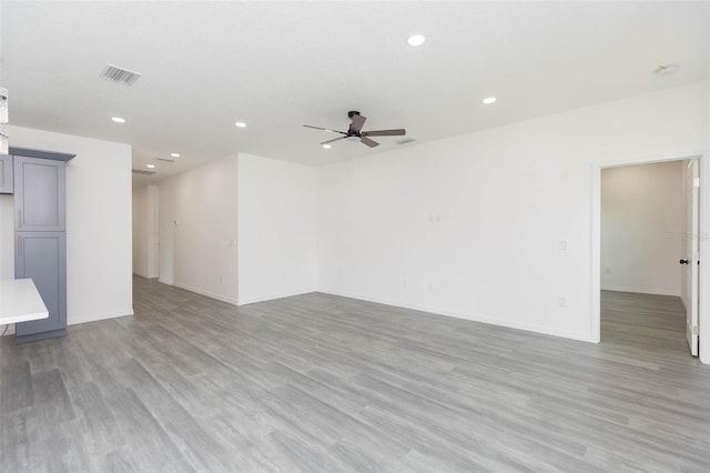 empty room featuring light wood finished floors, ceiling fan, baseboards, and recessed lighting