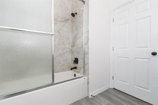 full bath featuring enclosed tub / shower combo, wood finished floors, and baseboards