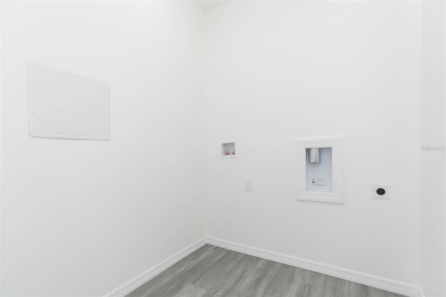 washroom with hookup for a washing machine, electric dryer hookup, light wood-type flooring, laundry area, and baseboards