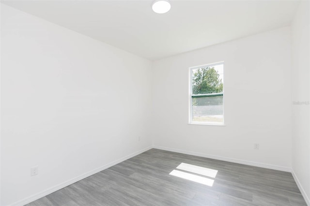 empty room featuring wood finished floors and baseboards