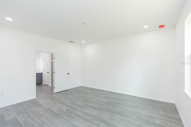 spare room featuring visible vents, baseboards, wood finished floors, and recessed lighting