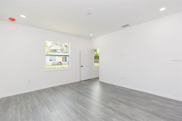 empty room with visible vents, baseboards, wood finished floors, and recessed lighting