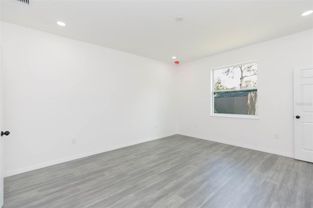 unfurnished room with recessed lighting, baseboards, and wood finished floors