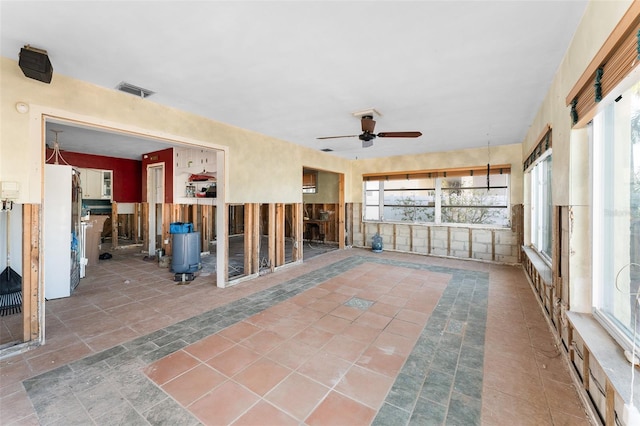 unfurnished sunroom featuring ceiling fan