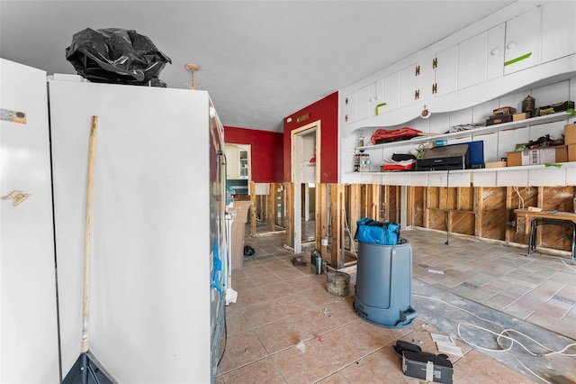 kitchen with white cabinetry and freestanding refrigerator