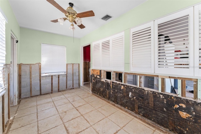 spare room featuring wainscoting, visible vents, and ceiling fan