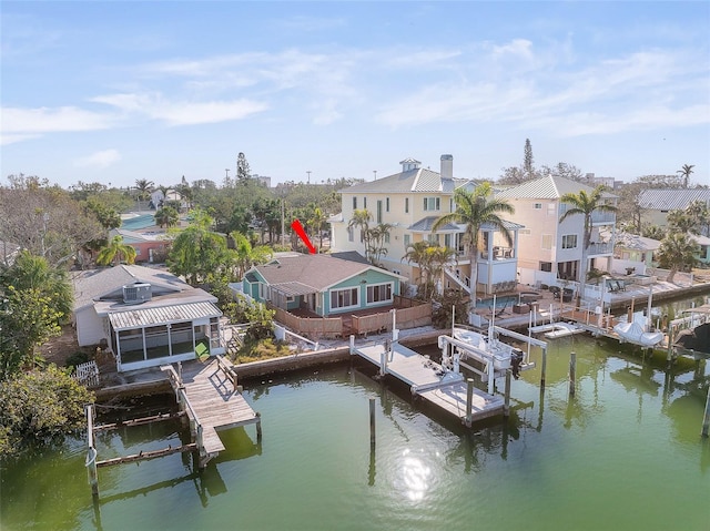 view of dock with a water view, boat lift, and a residential view