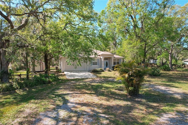 view of yard with a garage, driveway, and fence