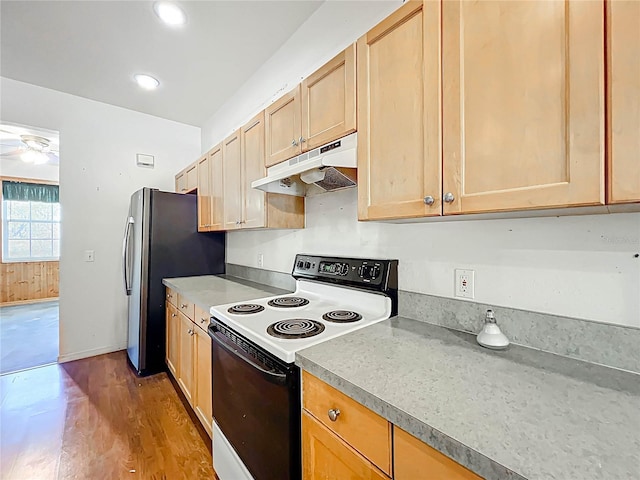 kitchen with baseboards, electric stove, wood finished floors, freestanding refrigerator, and under cabinet range hood