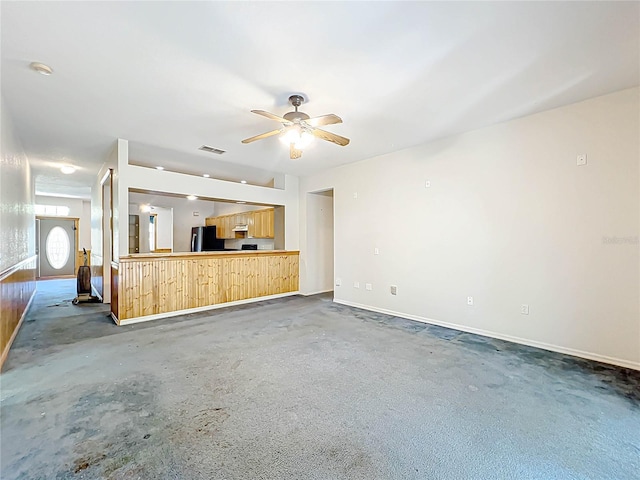 unfurnished living room featuring a ceiling fan, visible vents, and baseboards