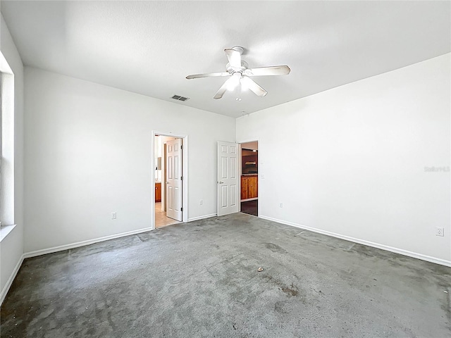 carpeted spare room with visible vents, a ceiling fan, and baseboards