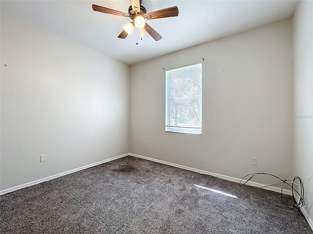 carpeted empty room with ceiling fan and baseboards