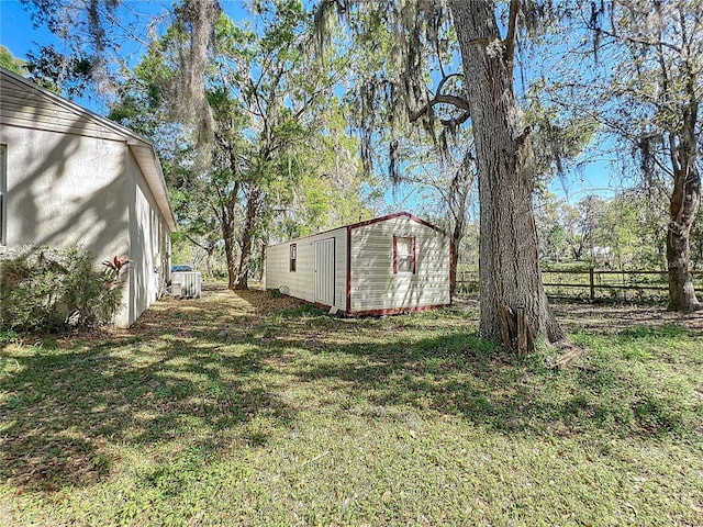 view of yard featuring fence and an outdoor structure