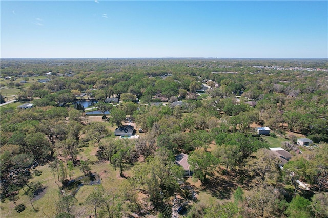 birds eye view of property featuring a water view and a view of trees