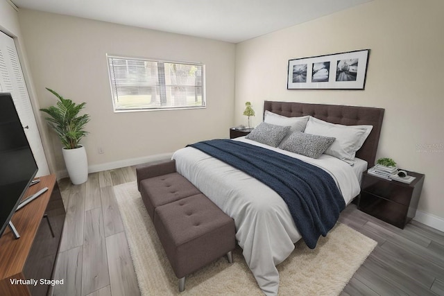 bedroom with baseboards and wood finished floors