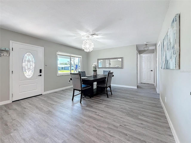 dining space featuring visible vents, baseboards, and wood finished floors