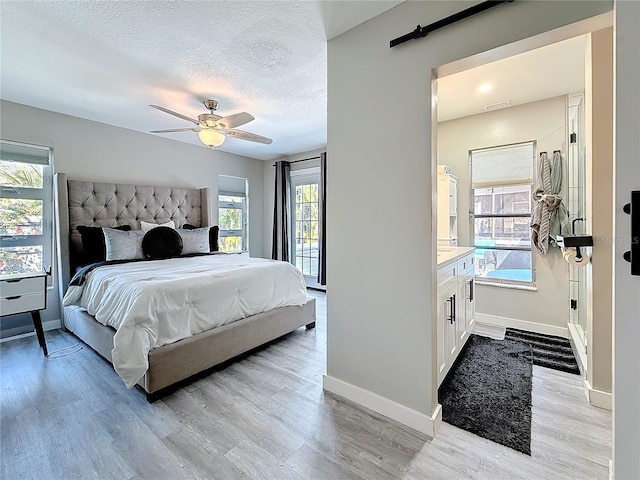 bedroom featuring visible vents, baseboards, a textured ceiling, and light wood finished floors