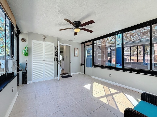 unfurnished sunroom with ceiling fan