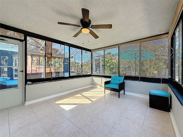 unfurnished sunroom with a ceiling fan