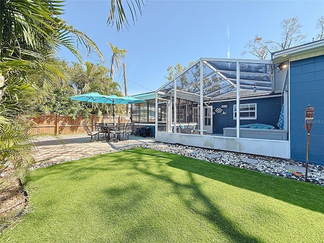 view of yard featuring glass enclosure, fence, and a patio