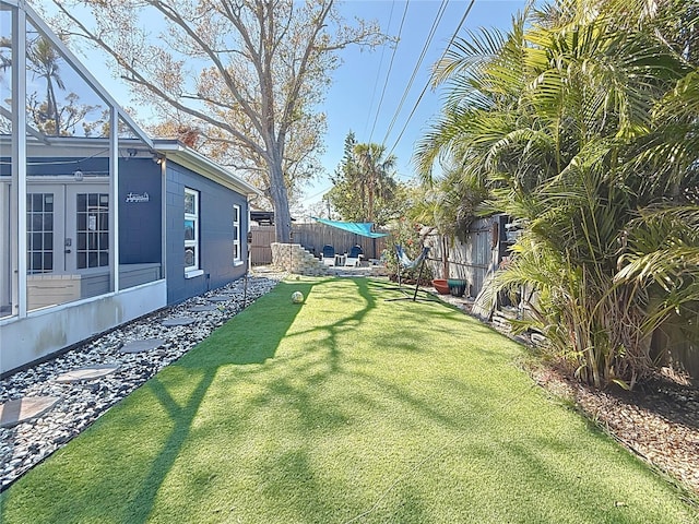 view of yard with french doors and a fenced backyard