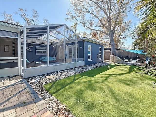 view of yard with french doors, a patio area, fence, and a lanai