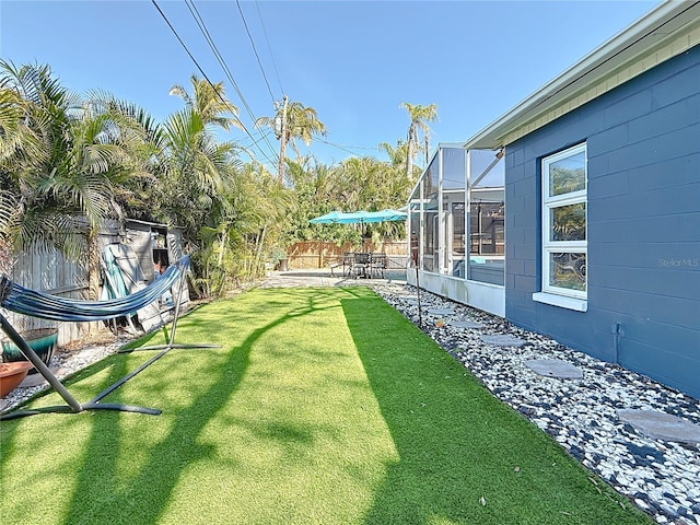 view of yard with a patio area, a fenced backyard, and a lanai