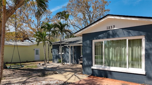 view of property exterior featuring a shingled roof and concrete block siding