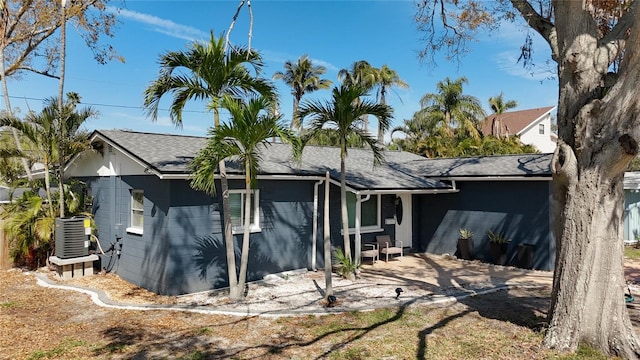 back of property featuring roof with shingles and central air condition unit