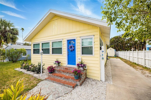 view of front facade featuring a front yard and fence