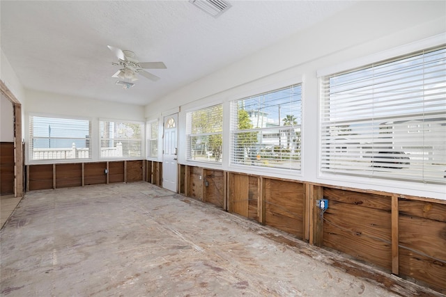 unfurnished sunroom with a ceiling fan and visible vents