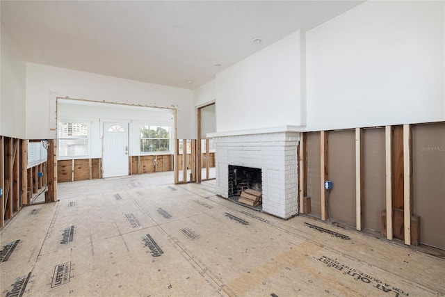 unfurnished living room featuring a brick fireplace