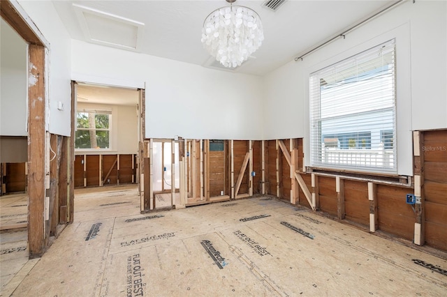 interior space with attic access, visible vents, and a notable chandelier