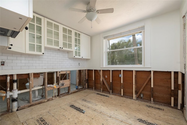 kitchen with light countertops, backsplash, glass insert cabinets, white cabinetry, and ceiling fan