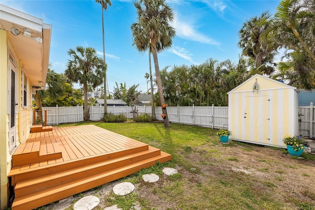 view of yard featuring a fenced backyard, an outdoor structure, a deck, and a storage unit