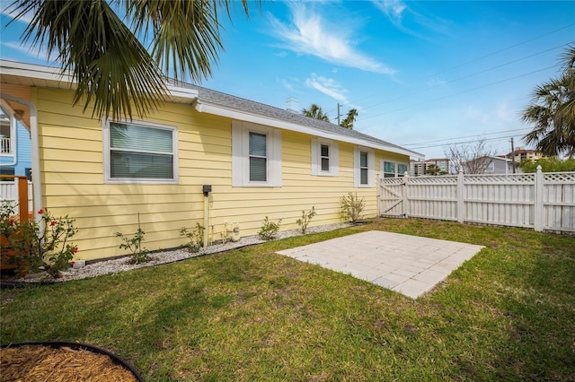 back of house featuring fence, a patio, and a lawn